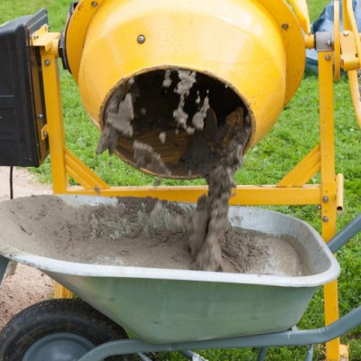 Worker fills cement concrete mixer